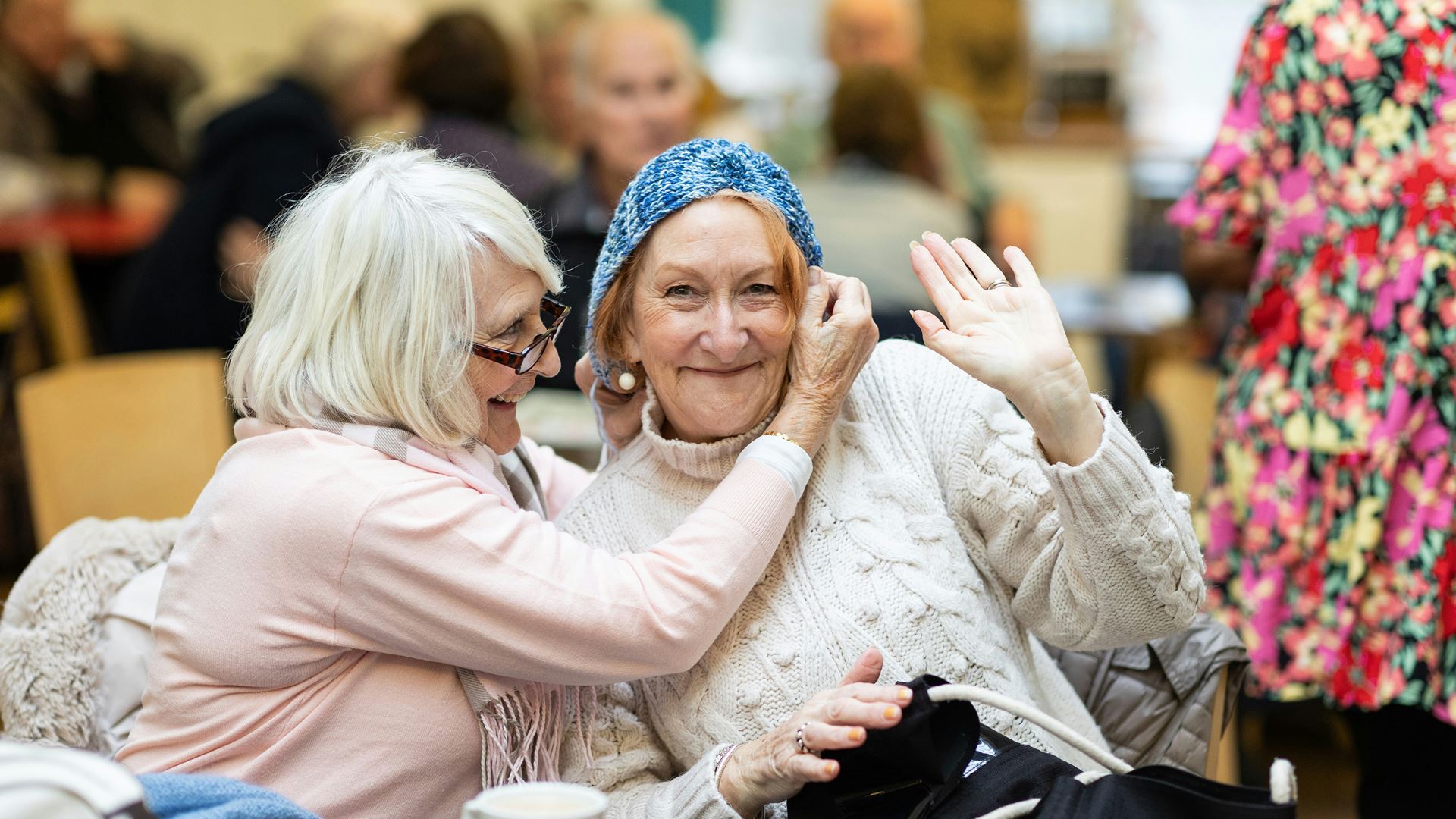 Zwaaiende gepensioneerde vrouw met vriendin