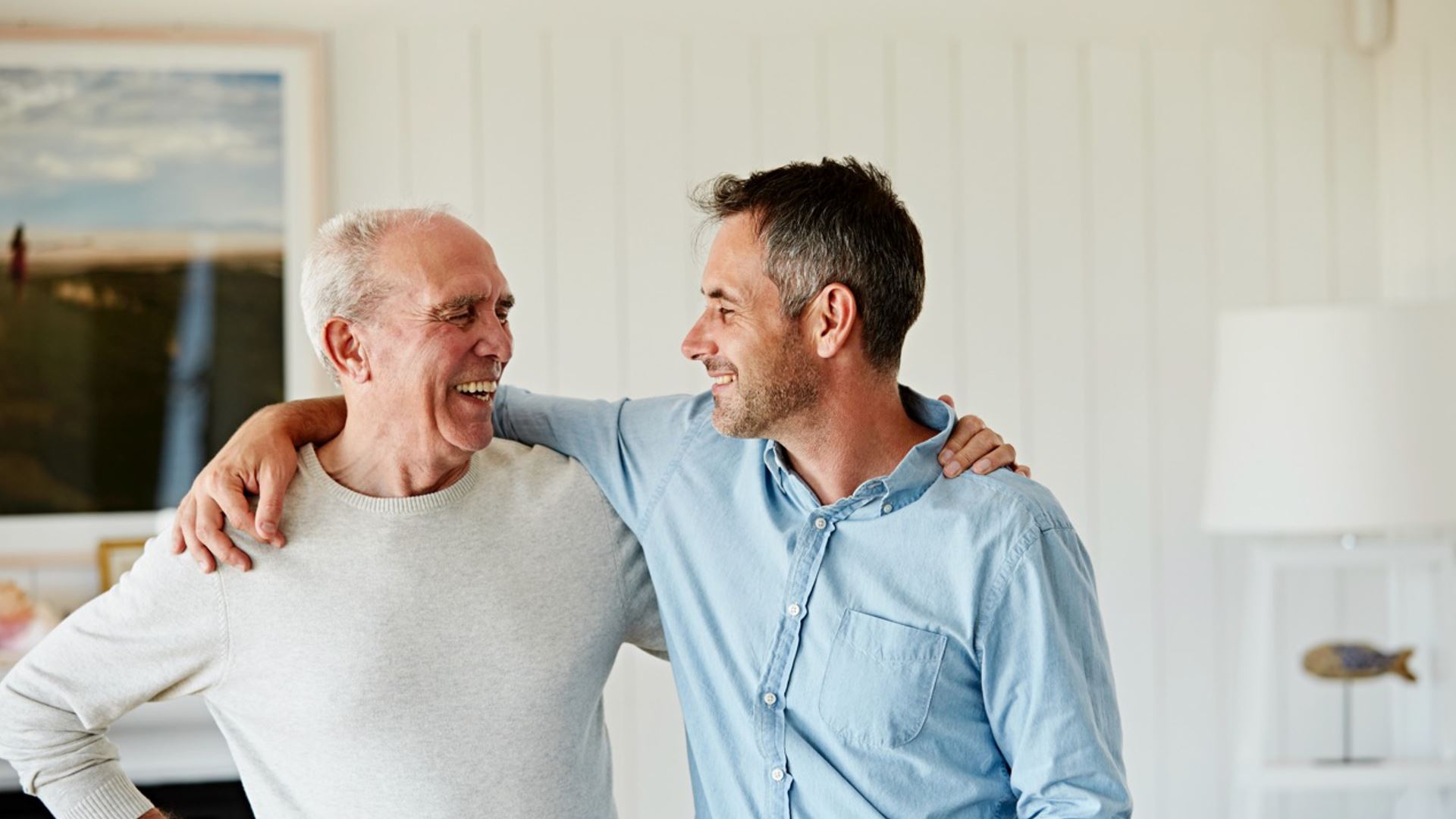 Gepensioneerde man met zoon arm in arm