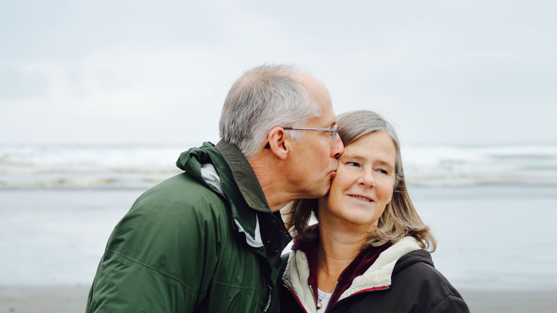 Ouder gelukkig stel op strand kus gevend