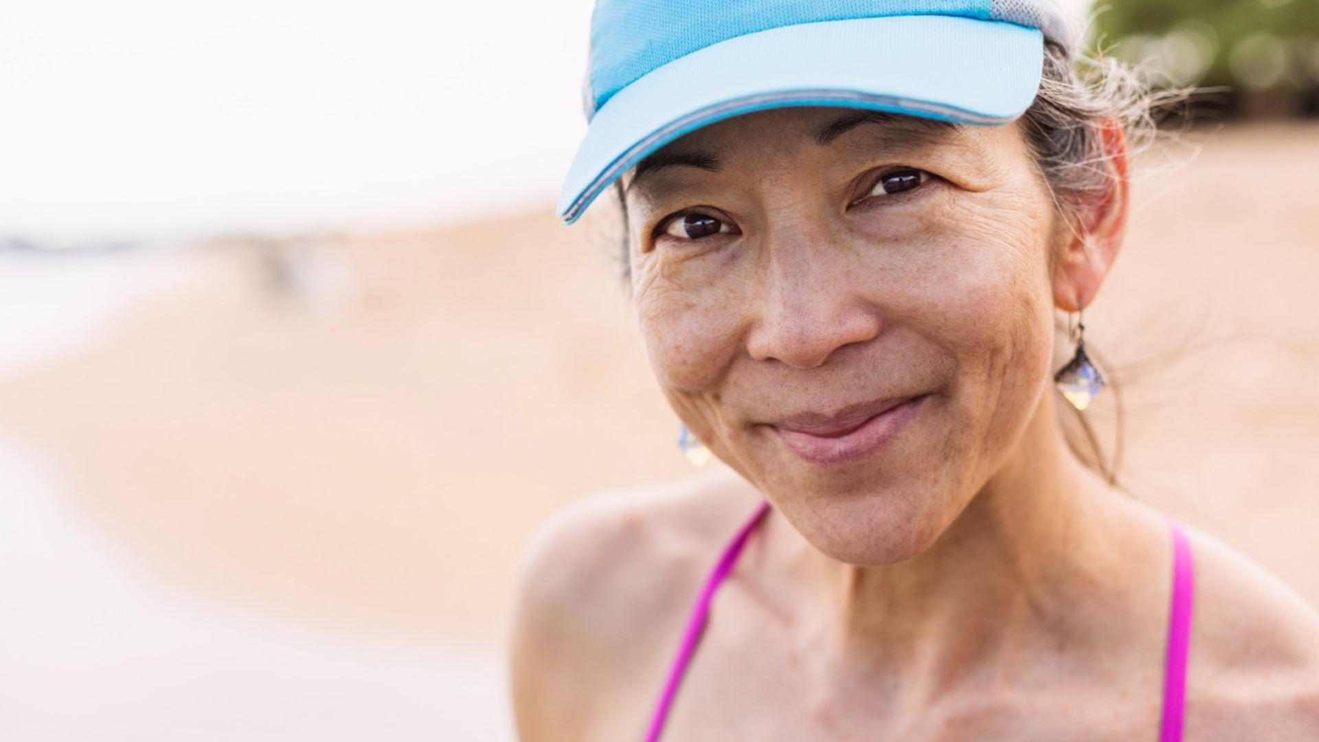 Tevreden vrouw met blauwe pet kijkend in de camera